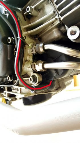 Close-up of the OEM cable (red line) as it wraps around the front of the clutch and then to the starter post on the starter.
