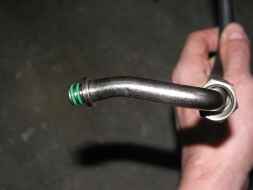This is the end of the oil line that is connected to the output on the engine.  Notice that goofy bend?  That's what's needed for the line to clear the engine.  The only tools needed are two 19mm open-ended wrenches, flat-bladed screwdriver, and a 5mm Allen wrench.  Use one wrench to hold the connector nut and the other to remove/replace the oil line coupling nut.
