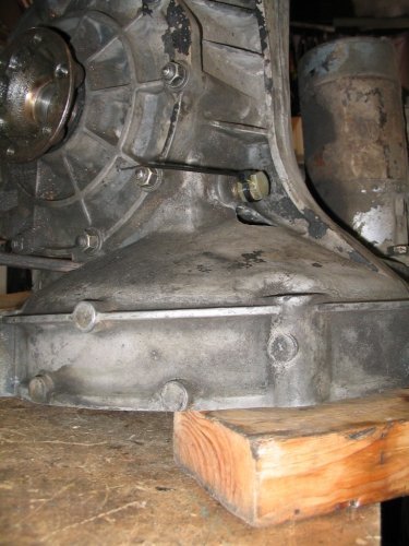 My rebuilt tranny still had oil in it.  But tipping it on it's bell-housing would let the oil leak out the breather port.  So I pushed a plug into the hole on the breather and securly zip-tied it.  Worked perfectly to hold the oil in while I swapped tail covers.
