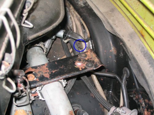 Location of the upper left nut (17mm) in the engine bay where the tranny mounts to the engine.  The bolt is on the inner side of the starter and is used to hold the starter as well as affix the tranny to the engine.  This nut can be removed without having to hold the bolt head as the bolt head is captured against the starter and thus won't rotate on you.
