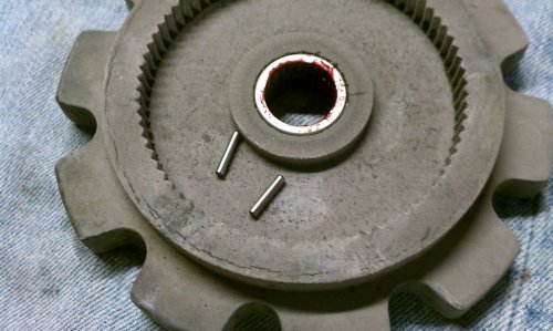 All the bearings are roller bearings and they are held in with the grease.  When cleaning the grease and wiping the bearings they will most likely fall out so work over a soft, plush towel to keep them from bouncing away.  Pack the bearings and cage surfaces with fresh grease and slip any fallen bearings back in.  You should see no gaps between the bearings.  Pack more grease in when they're all in and roll them around with your finger to spread the fresh grease around.  It will hold them in there.
