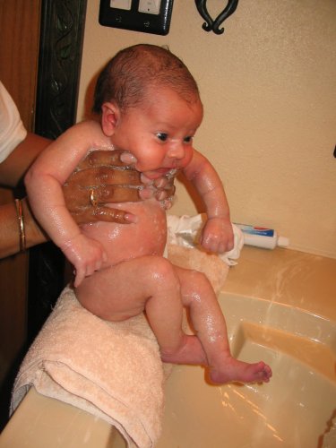 Getting a bath in the bathroom sink from Grandma Mimi.
