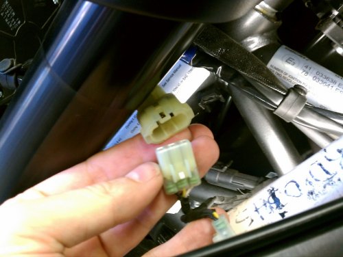 The 3-pin connector apart.  Next up is the 2-pin connector.  After that the headlight can come completely off the bike.  This is done by pushing the assembly up in the same direction as the fork tubes until the bracket comes off the upper pegs.  Pull it forward a little to clear the pegs then downward (if a Strada windshield is in the way) and forward to clear the bike.
