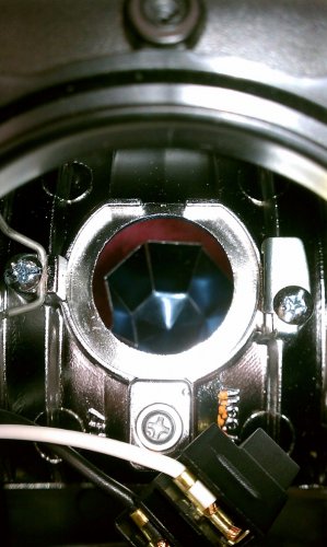 Looking down into the bulb housing cavity.  The reflector will need to be moved forward just a tad, like a couple millimeters, to clear the taller HID bulb.  If you get flickering or the bulb doesn't light up after installing the HID bulb then chances are good that the bulb is touching the reflector and shorting out.
