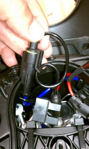 To make it a little easier getting both of the HID wires into the small space I put a single loop in the wire, as shown.  Then stuff it in there with the red wire.
