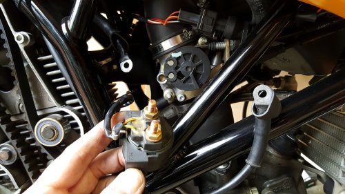 The starter relay removed.  You will need to disconnect the cables first in order to remove it.
