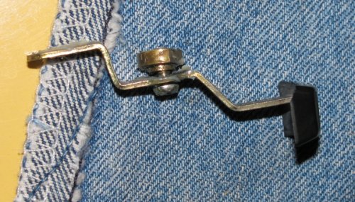 In case you drop the parts, here's how the bits go together.  The washer goes on the screw and then the screw goes into the lever and the bushing.  The flat side of the bushing faces the thumb pad.
