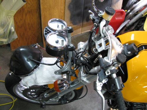 In order to remove the upper triple-tree the headlight needs to be removed and then the U-shaped ladder part that the headlight attaches to is then removed.  Remove the two nuts at the bottom of the ladder then lift it up.  Also, disconnect the headlight connector and put the headlight out of the way.
