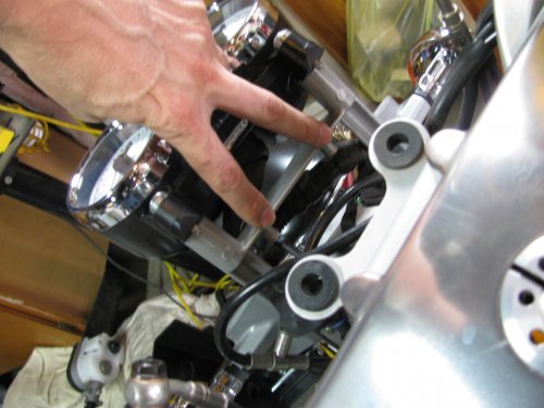 My fingers are pointing to the two pins that fit into the two rubber grommets that are part of the upper triple tree (visible in the foreground).
