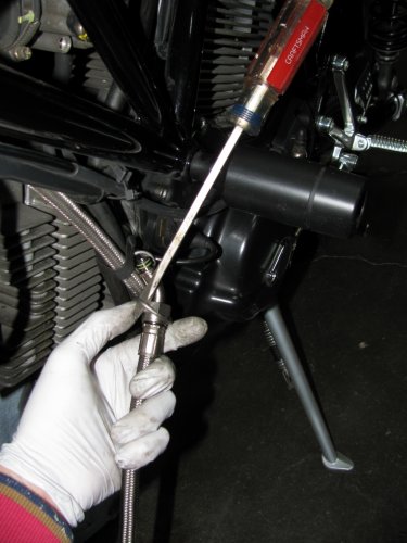 With patience and a little wiggling, use the screwdriver to help coax the coupling nut into the bracket.
