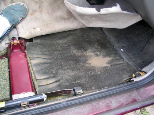 First layer under right front carpet, foam padding like the rear but bonded to a protective rubber(?) sheet.
