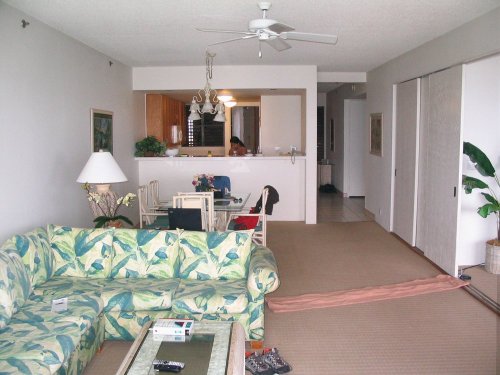 Day 3
Living/dining room and kitchen view.  Behind kitchen was front door.  To the left is the master suite w/balcony.  Laundry, linen, spare bedroom and second bath are to the right of the kitchen/dining rooms.  There is no A/C so cooling is done by opening the sliding glass doors and adjusting the large-slatted blinds found in the kitchen and spare bedroom.  Luckily, there are adjustable ceiling fans as well.
