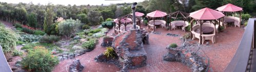 The patio before sunset.  This is a photo-stitched 180-degree view.  You can see the deck railings on either side of the picture and the deck was straight, not V-shaped as it appears to be.  It's best to view this picture in full-view mode (so it fills the screen) and scroll the picture left/right using the scroll bar, as if you were standing there and looking off the deck.
