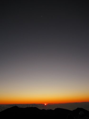 Sun rise with the moon straight above.
