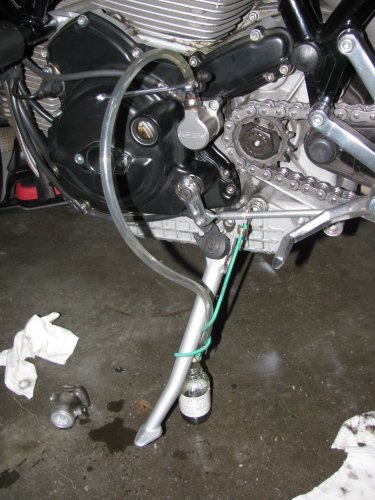 Use an 8mm open-ended wrench to crack open the bleeder nipple when bleeding the clutch slave.  I used clear tubing, bungeed to the kick-stand, and let it drain into a glass container.  I bled my system until fresh fluid appeared.  Remember to keep an eye on the reservoir!  Oh yeah, you no longer need the plastic wrap cover.  When done, make sure the reservoir is about 3/4 full, then insert the rubber boot and secure the cap.
