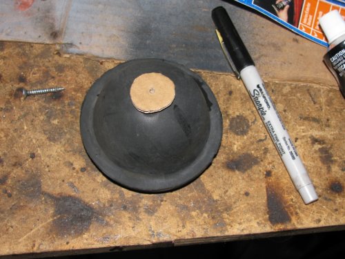 Through the rubber cover
The following is the method I used on the left side after trying the right side by using the hard cover (described after this procedure).  This is SO much easier to install and route wires, however, you MUST make sure you seal the gasket to the rubber boot so as to keep water out.  I personally think this is the best way to do it with the kit I used.

I used a scrap piece of cardboard, cut in a 7/8" diameter circle, and traced the back side of the low beam rubber cover using a permanent marker.
