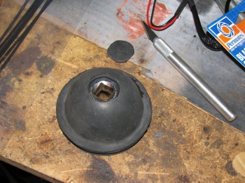 To hold the cover up while cutting, I used a 1/2" socket underneath.  Use a very sharp Xacto blade and cut s-l-o-w-l-y and carefully.
