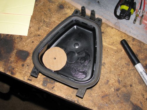 Through the hard cover
Just an FYI:  I do NOT recommend this method!  PITA if you have any issues.  Go through the rubber cover.

Make a template that is 7/8" in diameter and trace with a permanent marker.  Or put a nail or screw into the center of the circle and tap it so it leaves a dimple -- that's where you will drill.  I used this location because it gave me the most slack in the wiring.  The shop that does this recommended not putting the gasket in the center of the hard cover because there wouldn't be enough wiring slack.
