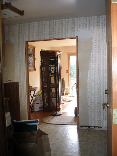 Before:  From inside garage looking into dining room.  Double-pocket door opening.  Trim and some original wallpaper removed.
