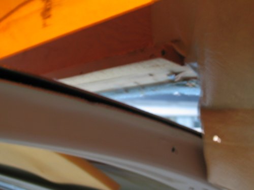 In the Bus, looking rearward down the left side of the Bus, pushing the top up so the bottom framing is lifting up from the roof.
