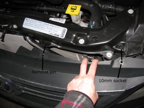 Left side shown.  Right is just like the left side.
After removing the bumper skin fasteners remove the 10mm bolt and pin retainer.  Do this for both sides (remove all fasteners).  This will allow the front fascia and bumper skin to be pulled back enough to get to the head lights.  The bumper is still attached to the vehicle by lower fasteners but for this situation it doesn't need to be fully removed.

