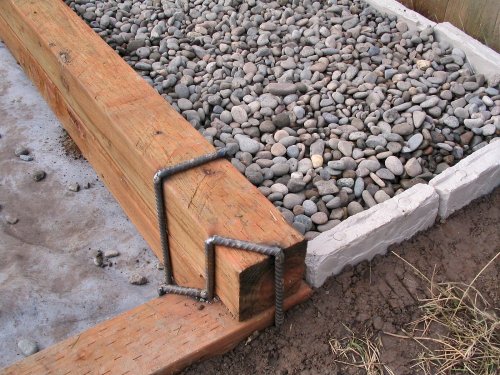 How the river rock is contained, using plastic rock that's simply staked into the ground (looks good past 10' ;-) ).  Yes, I got creative on that last staple :-)
