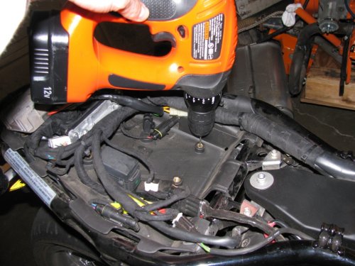 Gently and at medium speed, drill a hole through the center.  All the way through.  You don't need a big drill either, the brass and plastic will drill easily.  Go on...do it!
