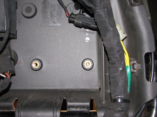 Here you can see the drilled holes.  The left one is after drilling with the larger bit.  The right hole is just after I drilled with the pilot bit.  I have a light below the seat pan.
