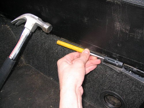 Drift the hinge pins back in.  Tap in with a hammer then use the drift to finish.  When inserting or removing the hinge pins it's easiest to drift them in the direction of center-of-car to outside.  Applying a thin coat of oil or grease helps insertion and operation of hinge.
