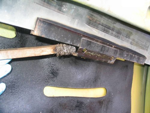 Using a wire brush to clean the channel.
