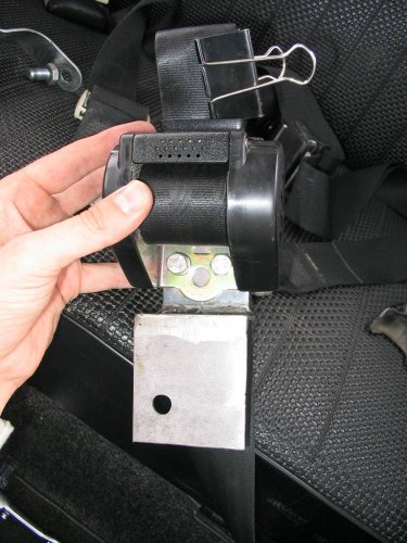 This is the way you would actually do it; mount the retractor first THEN bolt the bracket and lower outside mount to the body.  These two bolts should be tightened firmly but not by a gorilla i.e. don't over do it!
