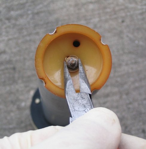 (This is a copy of the last picture but the disassembly is the opposite of the assembly :-) ) Unbend the tabs surrounding the retaining nut and remove the nut.  Grab the top of the sender assembly and pull the tube away from the top.  This will expose the float and wires.
