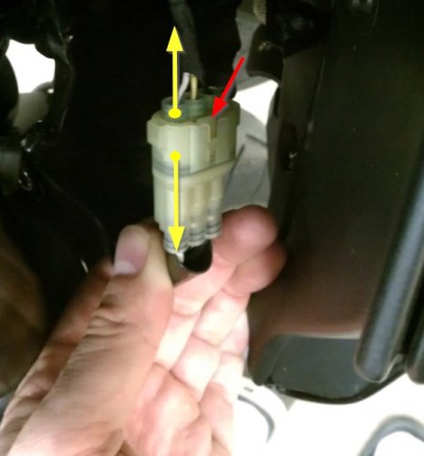 To separate the two electrical connectors simply lift the tab (red arrow) and gently pull the male connector (what I'm holding) from the female (top) (yellow arrows). 
