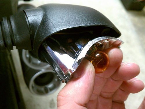 Grasp the original bulb to gently pull the reflector straight out.  I show this angled so the inside end can be seen.  Gently push the bulb in just a little bit and then rotate it to remove it.  Mine were in there quite snug!  The LED unit goes in the same way as the bulb.  Put everything back together.  Done!
