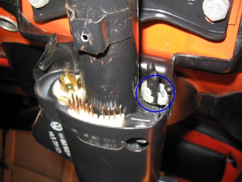 The blue circle shows where the collar will be located, within the steering column collar.  Note that in this picture the collar isn't pushed all the way in -- it's a pain to remove it as you have to get under the steering column and use an object to pry the collar free from the retaining rings on the nozzles.  Once I had it out I wasn't about to put it back in just for a picture.  If you have one in your car you'll see it, plain as day, and you won't be able to remove your switch gear out until that damn collar has been pried out.
